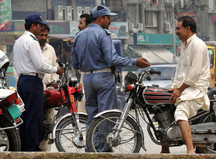 This image shows a traffic police official interacting with a citizen. — Traffic Police Punjab website